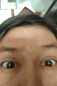 a close up of a person 's face with their eyes looking at the camera