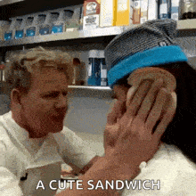 a man is putting a sandwich on a woman 's face and says a cute sandwich .