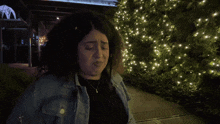 a woman is standing in front of a christmas tree and the word you is above her