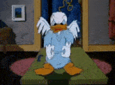 a cartoon duck is sitting on a table with its wings spread .