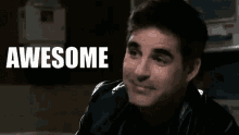 a man in a black leather jacket is smiling with the words awesome behind him .