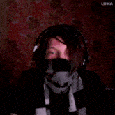 a person wearing headphones and a scarf with the word luma behind them