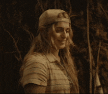 a woman wearing a hat and a striped shirt smiles