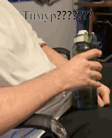 a person is holding a green water bottle with the words timyp written on it