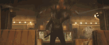 a man in a superhero suit is standing in a room with a chandelier hanging from the ceiling