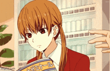 a girl in a red suit is holding a magazine with foreign writing