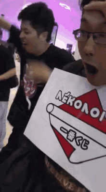 a man with glasses holds a sign that says neko on it