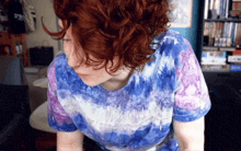 a woman wearing a blue and purple tie dye shirt