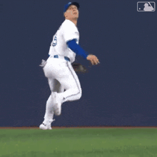 a baseball player is jumping in the air to catch a ball on a field .
