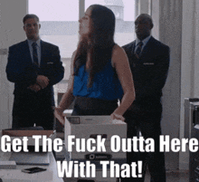 a woman in a blue shirt is holding a box and says get the fuck outta here with that ..