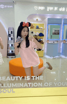 a girl taking a picture of herself in front of a mirror with the words beauty is the illumination of your soul