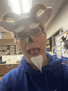 a woman in a blue hoodie with a fake beard and horns on her head
