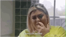 a woman covering her nose with her hand and says i dunno i 'm petrified