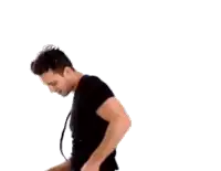 a man in a black shirt is holding a black object in his hand .