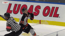 a hockey game is being played in front of a lucas oil banner