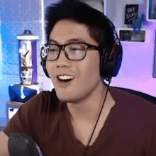 a man wearing glasses and headphones with a sign on the wall that says wet