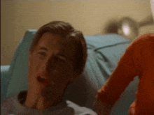 a man is laying in a hospital bed with a woman standing next to him