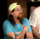 a man with long hair and a beard is wearing glasses and a yellow hat