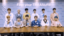 a group of young men sitting at a table with the words " find your treasure " written on the wall behind them