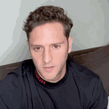 a man wearing a black shirt that says hugo on the collar