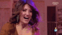 a woman is dancing on a stage in front of a purple chair with the number 2 on it