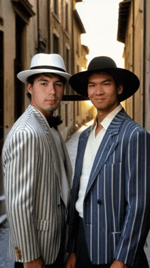 two men standing next to each other one wearing a hat