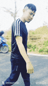 a man is walking down a road with an oppo reno7 pro 5g phone