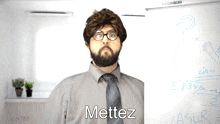 a man wearing glasses and a tie says mettez in front of a white board