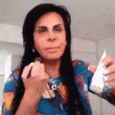 a woman is applying makeup to her face with a brush while holding a bottle of lotion .