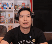 a man wearing headphones and a t-shirt that says " make it "