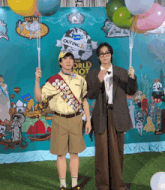 two men are holding balloons in front of a sign that says outing 2015