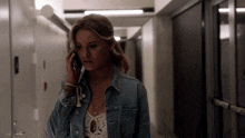 a woman in a denim jacket talking on a cell phone