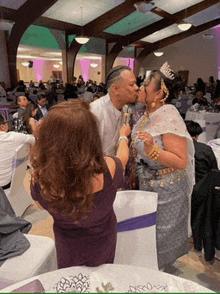 a man kissing a woman on the cheek at a wedding
