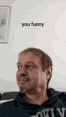 a man with a beard wearing a black shirt that says ' you funny ' on it