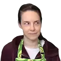a woman wearing a purple hoodie and a green apron with avocados on it .