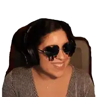 a woman wearing headphones and sunglasses is smiling and wearing a striped shirt