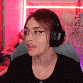 a woman wearing glasses and headphones is making a funny face