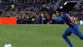 a soccer player kicks a ball on a field with an unicredit sign in the background