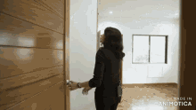 a woman stands in an empty room with the words made in animotica on the bottom