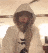 a woman is wearing a white hoodie with a bunny ear .