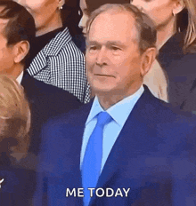 a man in a suit and tie is standing in front of a crowd of people and says `` me today '' .