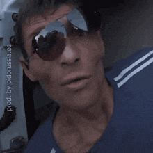 a man wearing sunglasses and a blue shirt says " хорошего " on the bottom right