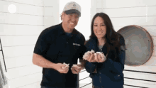 a man and woman are holding seashells in their hands and smiling .