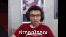 a man wearing headphones and glasses is sitting in front of a computer screen and making a funny face .