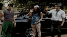 a group of people standing in front of a car with the website www.thaitv3.com