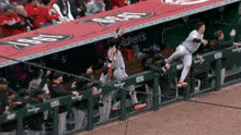 a baseball player leaps over a fence in front of a children 's ad