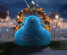 a blue monster with one eye is standing in front of a halloween wreath