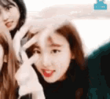 a group of girls are standing next to each other and making a peace sign with their hands .