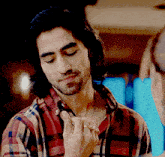 a man wearing a plaid shirt has a ring on his left hand