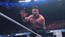 a man in a wrestling ring is holding a microphone with the word ucsd on it